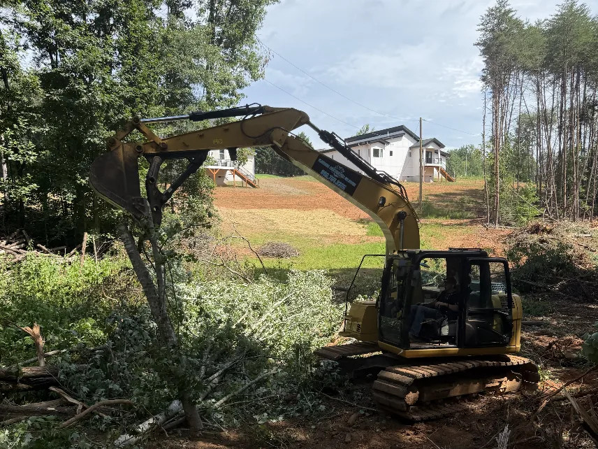 Platinum Construction & Crane excavator grading a sloped, freshly cleared lot in the NC Foothills