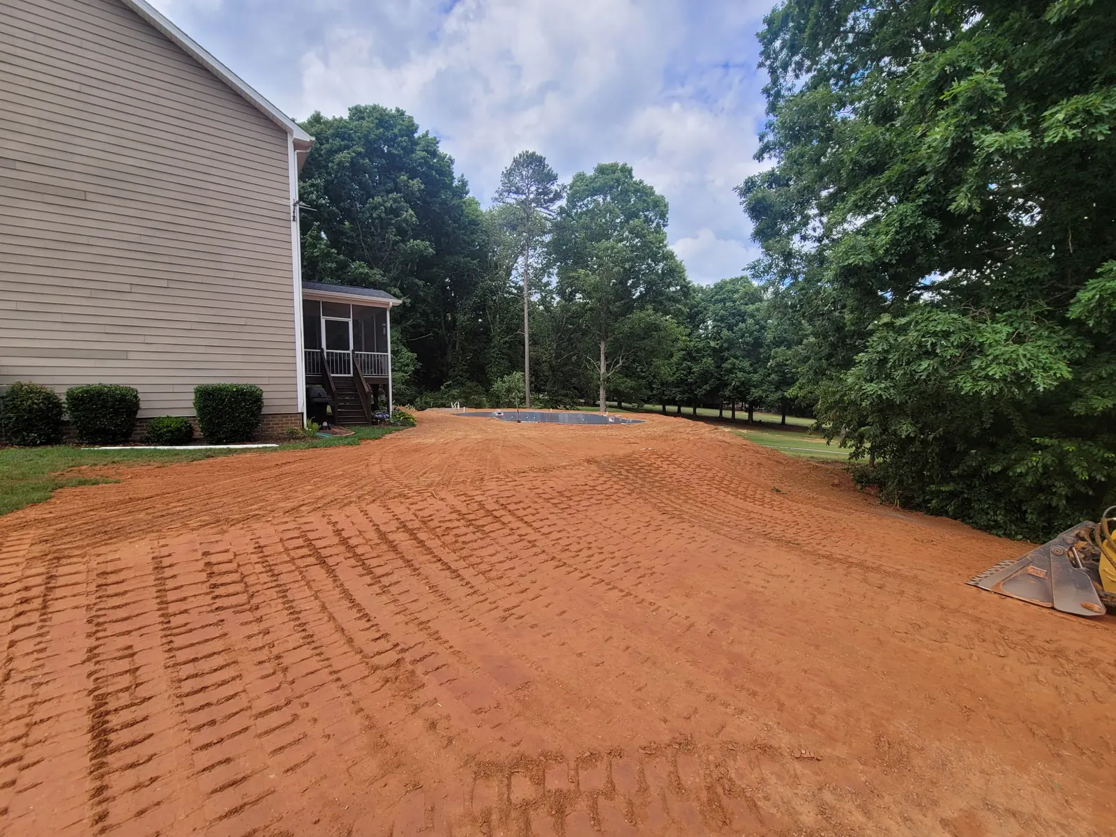 A back yard regraded and smoothed for seeding beside a two-story home &mdash; Little Acres Grading